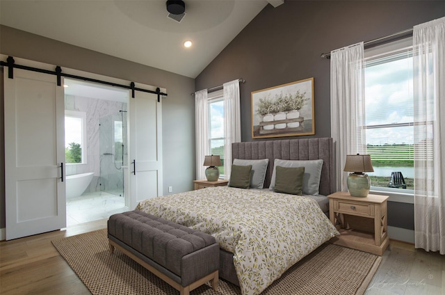 4410 Jozwiak Rd, Chappell Hill, TX 77426 - bedroom featuring a barn door, lofted ceiling, multiple windows, light wood-type flooring, and recessed lighting