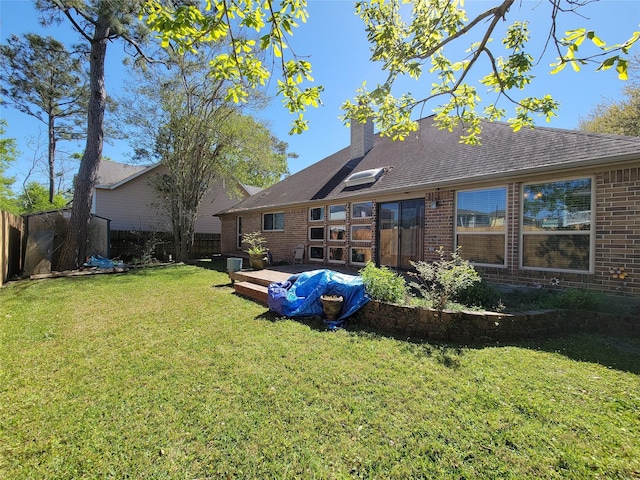 4021 Fatta Dr, Dickinson, TX 77539 - back of house featuring brick siding, a fenced backyard, a chimney, a deck, and a shingled roof