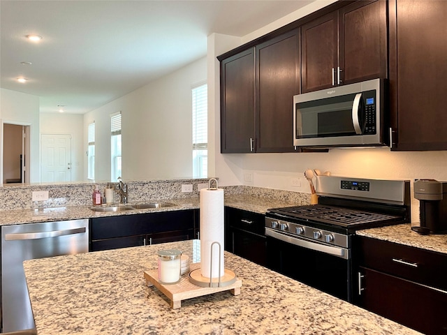 5835 Finely Run St, Spring, TX 77373 - kitchen with appliances with stainless steel finishes, light stone countertops, dark brown cabinets, and recessed lighting