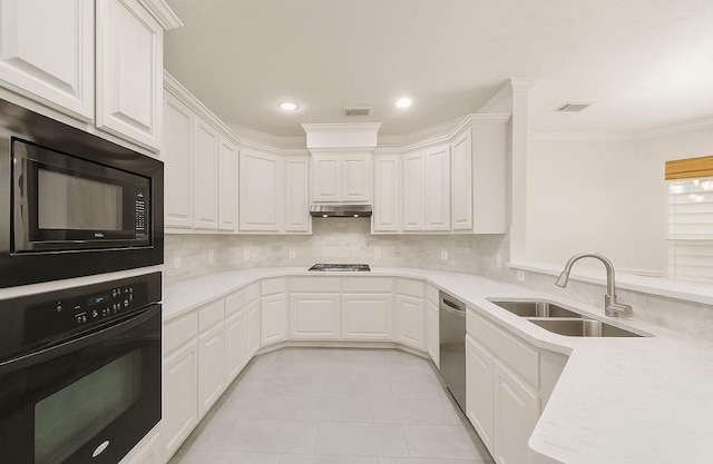1517 Asbury St, Houston, TX 77007 - kitchen with black appliances, under cabinet range hood, decorative backsplash, white cabinets, and crown molding