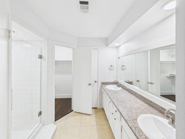 8918 Bold Forest Dr, Houston, TX 77088 - bathroom featuring a spacious closet, a stall shower, double vanity, and tile patterned floors