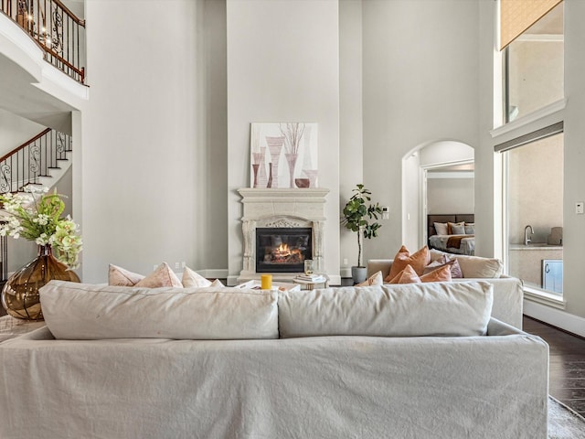11913 Barryknoll Ln, Houston, TX 77024 - living area featuring a high ceiling, arched walkways, dark wood-style floors, stairs, and a premium fireplace