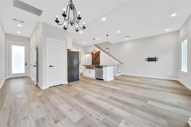 6727 Parker Oaks Ln, Houston, TX 77076 - kitchen featuring freestanding refrigerator, stainless steel dishwasher, open floor plan, white cabinets, and light wood-style flooring