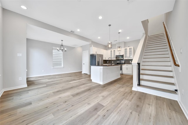 6727 Parker Oaks Ln, Houston, TX 77076 - kitchen with appliances with stainless steel finishes, a chandelier, dark countertops, white cabinetry, and open floor plan