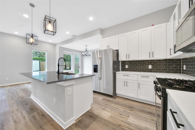 6727 Parker Oaks Ln, Houston, TX 77076 - kitchen with appliances with stainless steel finishes, a chandelier, light wood-style flooring, white cabinetry, and recessed lighting