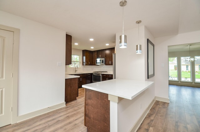 14835 Charlmont Dr, Houston, TX 77083 - kitchen featuring appliances with stainless steel finishes, dark brown cabinets, light wood-style flooring, tasteful backsplash, and light countertops