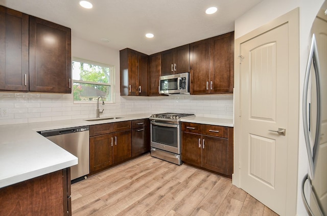 14835 Charlmont Dr, Houston, TX 77083 - kitchen with stainless steel appliances, light wood finished floors, decorative backsplash, light countertops, and dark brown cabinetry