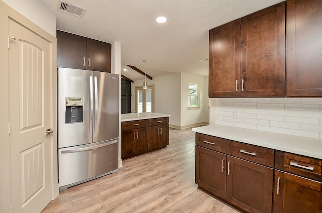 14835 Charlmont Dr, Houston, TX 77083 - kitchen with stainless steel fridge, tasteful backsplash, light wood-type flooring, light countertops, and lofted ceiling