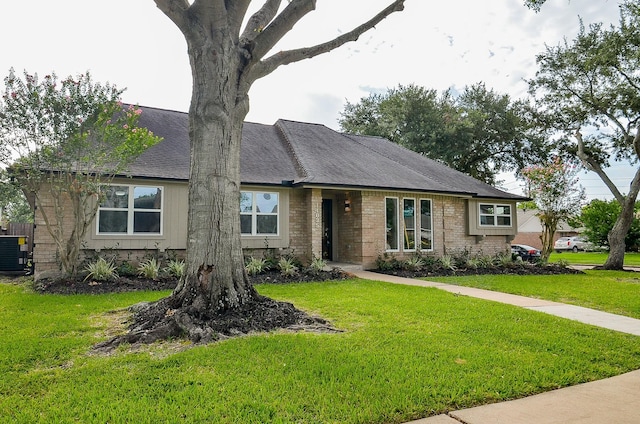 14835 Charlmont Dr, Houston, TX 77083 - view of front of home with a front yard, a shingled roof, and brick siding