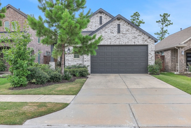12350 Castano Creek Dr, Humble, TX 77346 - french country home featuring brick siding, a garage, and driveway