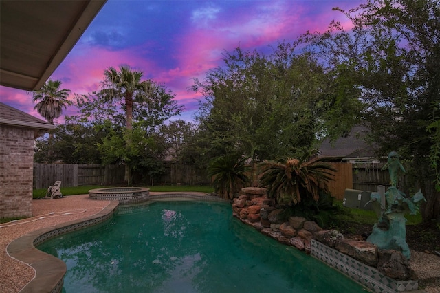 3106 Rainbow Ct, Pearland, TX 77584 - pool at dusk featuring a fenced backyard and a pool with connected hot tub