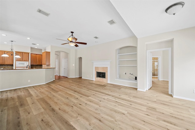 3106 Rainbow Ct, Pearland, TX 77584 - unfurnished living room featuring recessed lighting, light wood-style flooring, built in features, a ceiling fan, and arched walkways