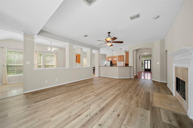 3106 Rainbow Ct, Pearland, TX 77584 - unfurnished living room featuring ceiling fan, light wood finished floors, ornate columns, and a high end fireplace