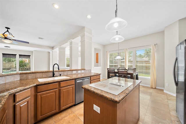 3106 Rainbow Ct, Pearland, TX 77584 - kitchen with appliances with stainless steel finishes, brown cabinets, plenty of natural light, a ceiling fan, and recessed lighting