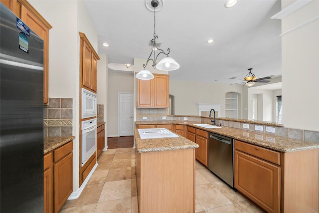 3106 Rainbow Ct, Pearland, TX 77584 - kitchen featuring white appliances, backsplash, a center island, ceiling fan, and light stone countertops
