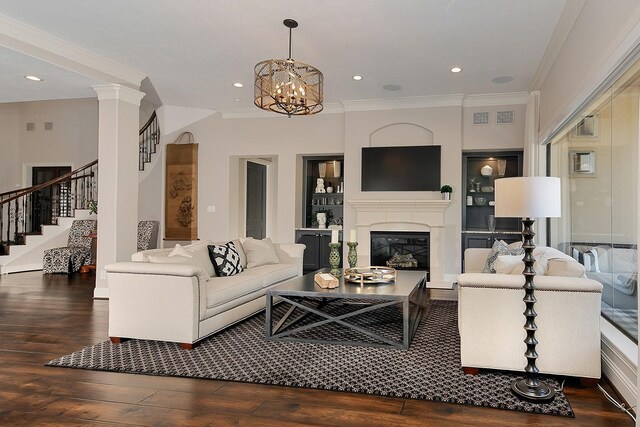 227 Starlight Pl, The Woodlands, TX 77380 - living area featuring hardwood / wood-style flooring, crown molding, stairs, a glass covered fireplace, and a chandelier