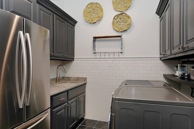 227 Starlight Pl, The Woodlands, TX 77380 - washroom featuring separate washer and dryer, a wainscoted wall, tile walls, cabinet space, and dark tile patterned flooring