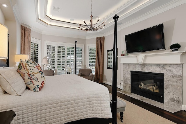 227 Starlight Pl, The Woodlands, TX 77380 - bedroom featuring a chandelier, wood finished floors, crown molding, a premium fireplace, and recessed lighting
