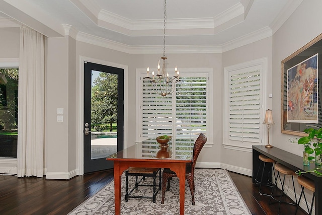 227 Starlight Pl, The Woodlands, TX 77380 - dining room featuring a chandelier, a raised ceiling, dark wood-type flooring, and ornamental molding