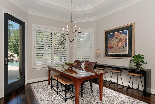 227 Starlight Pl, The Woodlands, TX 77380 - dining area with a chandelier, hardwood / wood-style floors, a tray ceiling, and ornamental molding