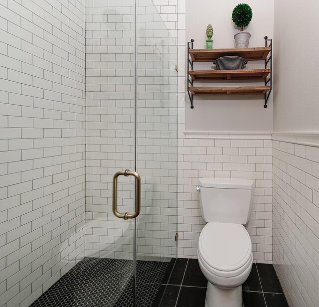 227 Starlight Pl, The Woodlands, TX 77380 - full bath with tile walls, a stall shower, a wainscoted wall, and tile patterned flooring