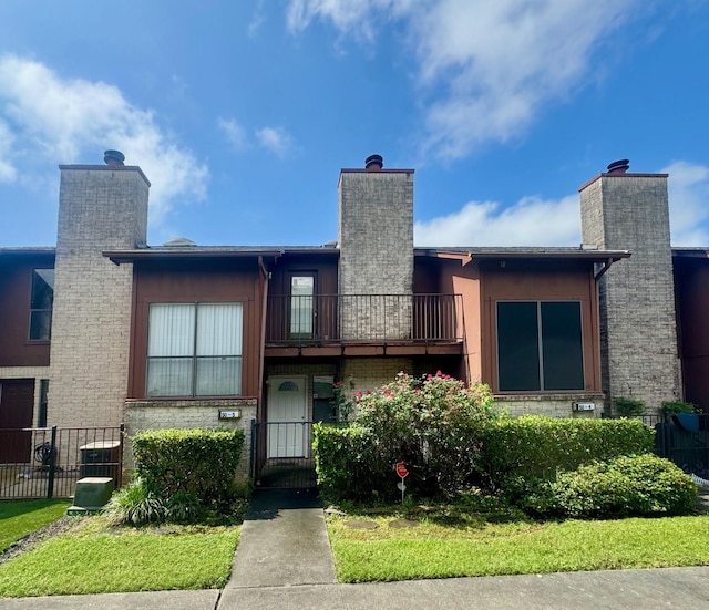 50 Evanston St Unit 5, Houston, TX 77015 - rear view of house with a chimney, a balcony, and a gate