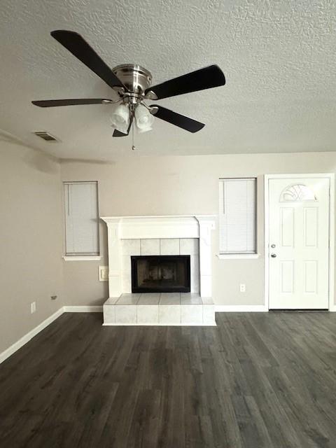 50 Evanston St Unit 5, Houston, TX 77015 - unfurnished living room with a textured ceiling, ceiling fan, wood finished floors, and a tile fireplace