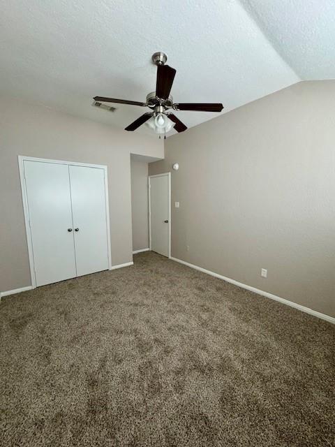50 Evanston St Unit 5, Houston, TX 77015 - unfurnished bedroom featuring carpet flooring, a closet, a ceiling fan, a textured ceiling, and lofted ceiling