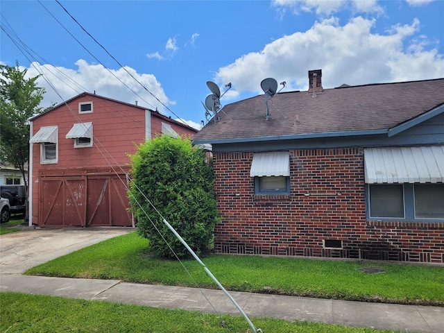 4301 Canal St, Houston, TX 77003 - view of home's exterior featuring brick siding, roof with shingles, concrete driveway, a chimney, and a lawn