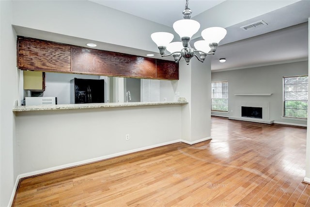 8100 Cambridge St Unit 49, Houston, TX 77054 - kitchen featuring black fridge with ice dispenser, healthy amount of natural light, wood finished floors, and a chandelier