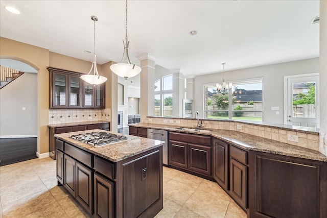 4503 Riley Way Ln, Sugar Land, TX 77479 - kitchen with appliances with stainless steel finishes, a kitchen island, tasteful backsplash, light tile patterned floors, and glass insert cabinets
