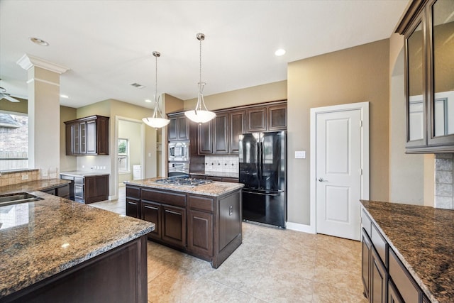 4503 Riley Way Ln, Sugar Land, TX 77479 - kitchen with appliances with stainless steel finishes, dark brown cabinets, backsplash, a center island, and recessed lighting