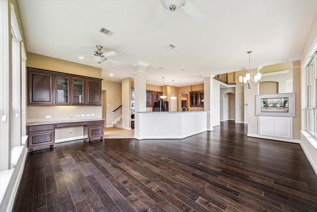 4503 Riley Way Ln, Sugar Land, TX 77479 - unfurnished living room with a ceiling fan, a chandelier, ornate columns, built in desk, and dark wood-style flooring
