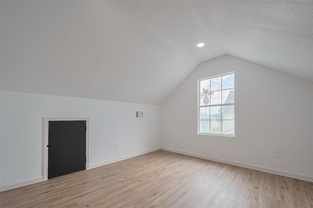 1014 13th St, Galveston, TX 77550 - bonus room featuring light wood-type flooring, vaulted ceiling, and a textured ceiling