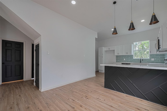 1014 13th St, Galveston, TX 77550 - kitchen with white cabinets, light wood-style flooring, a peninsula, light countertops, and recessed lighting