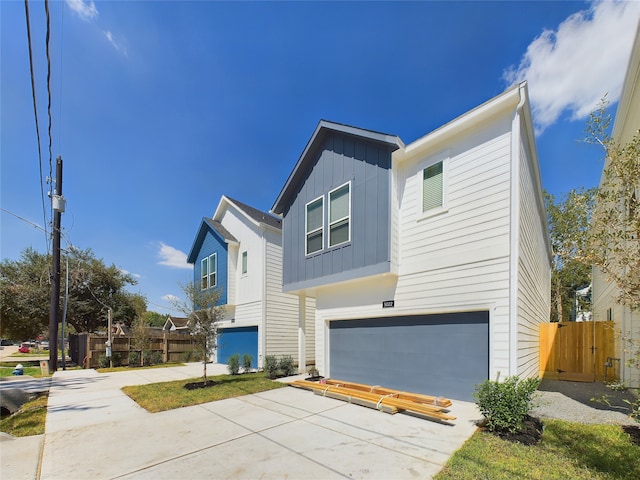 5022 Broom St, Houston, TX 77091 - view of front of house with board and batten siding, a garage, and concrete driveway