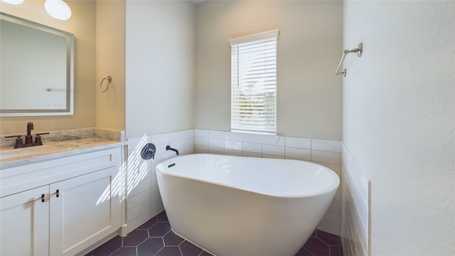 5022 Broom St, Houston, TX 77091 - bathroom featuring a freestanding bath, tile patterned flooring, vanity, tile walls, and a wainscoted wall