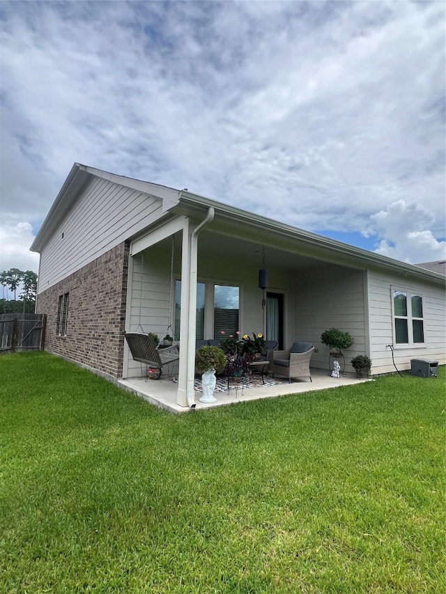11577 Gingerland Dr, Conroe, TX 77304 - back of house with a patio area, a yard, and brick siding