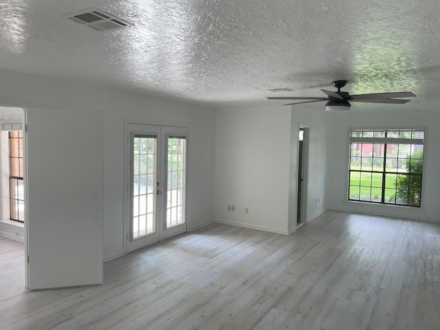 3419 Willowrun Dr, Montgomery, TX 77356 - spare room featuring light wood-style flooring, french doors, ceiling fan, healthy amount of natural light, and a textured ceiling