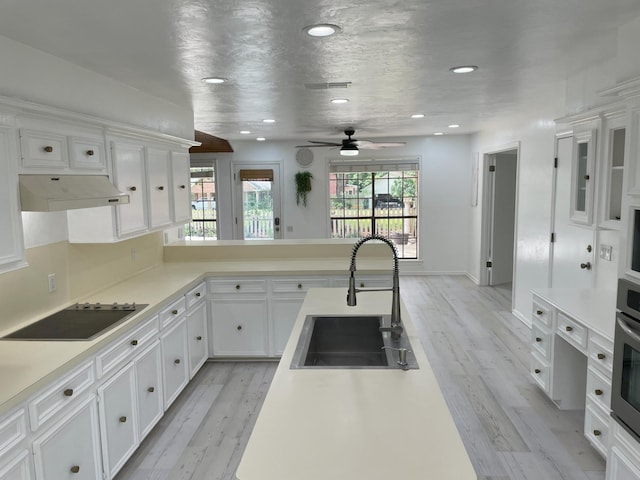 3419 Willowrun Dr, Montgomery, TX 77356 - kitchen featuring black electric cooktop, under cabinet range hood, white cabinetry, healthy amount of natural light, and recessed lighting