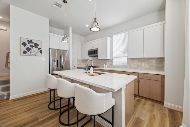 1804 Elysian St, Houston, TX 77026 - kitchen featuring appliances with stainless steel finishes, backsplash, light wood-type flooring, light countertops, and recessed lighting