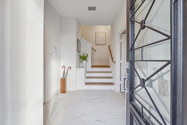1804 Elysian St, Houston, TX 77026 - stairway featuring marble look tile flooring and baseboards