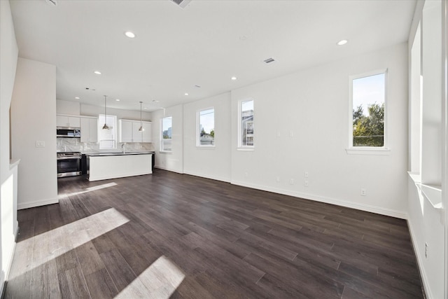 1812 Elysian St, Houston, TX 77026 - unfurnished living room featuring healthy amount of natural light, dark wood-type flooring, and recessed lighting