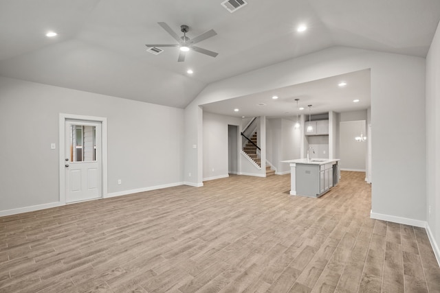 15215 Statice Trl, Houston, TX 77044 - unfurnished living room with lofted ceiling, light wood-style floors, stairs, a ceiling fan, and recessed lighting