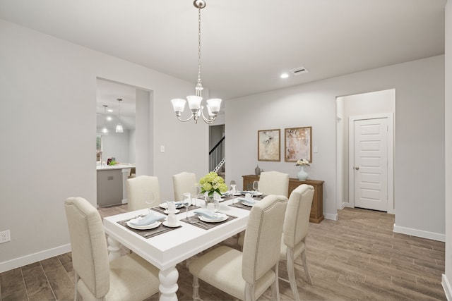 15215 Statice Trl, Houston, TX 77044 - dining area with light wood-style floors, a chandelier, stairway, and recessed lighting