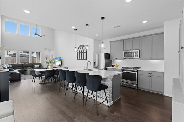 8814 Riverton Ridge Rd, Cypress, TX 77433 - kitchen featuring stainless steel appliances, gray cabinets, open floor plan, a kitchen breakfast bar, and ceiling fan