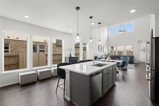 8814 Riverton Ridge Rd, Cypress, TX 77433 - kitchen with appliances with stainless steel finishes, open floor plan, gray cabinets, an island with sink, and light countertops