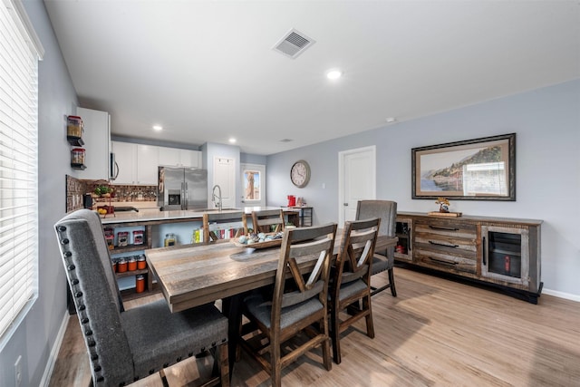 19919 Epirus Shores Dr, Hockley, TX 77447 - dining area featuring light wood finished floors, wine cooler, recessed lighting, and healthy amount of natural light