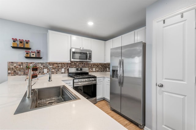 19919 Epirus Shores Dr, Hockley, TX 77447 - kitchen featuring stainless steel appliances, white cabinets, light countertops, tasteful backsplash, and recessed lighting