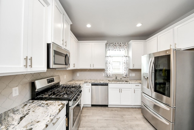 12306 Belhaven Terrace Dr, Houston, TX 77044 - kitchen with stainless steel appliances, white cabinetry, light stone countertops, and recessed lighting